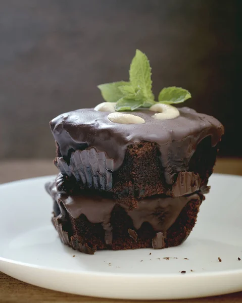 Homemade chocolate brownies topping with cashew nut and mint stacked on wood table with copy space. Brownie is one type of chocolate cake