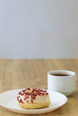 Ahşap masa, doğal ışık üzerinde siyah kahve kupa ile çörek
