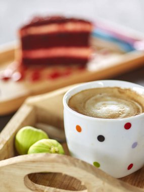 Kırmızı kadife kek kahve kupa ve yeşil incir ahşap tahta üzerinde