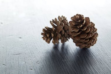 İki çam kozalağı bir ahşap masa doğal zemin üzerine closeup