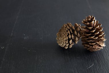 İki çam kozalağı bir ahşap masa doğal zemin üzerine closeup