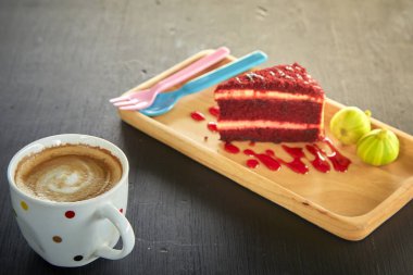 Kırmızı kadife kek kahve kupa ve yeşil incir ahşap tahta üzerinde