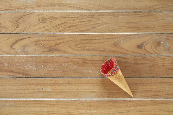 Flat-lay of waffle sweet cone on wooden Turquoise background. Sweet, summer and empty concept. Top view