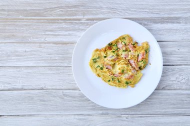 Omlet baharatlı biber ile bir plaka üzerinde beyaz bir ahşap masa ekşi domuz. boş alanı. Tayland Gıda