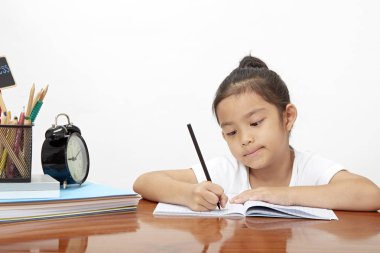 Asyalı küçük kız onun ödev, doğa yanındaki güneşli harfler için boş alan sabah yaparken konsantre