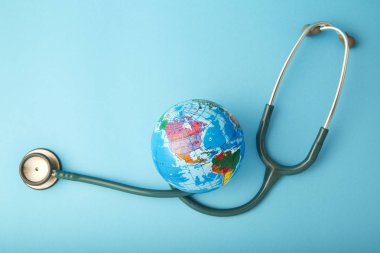 Stetoskop küre mavi zemin üzerine sarılı. Kaydetmek istiyorsunuz, küresel sağlık ve yeşil dünya gün kavramı.
