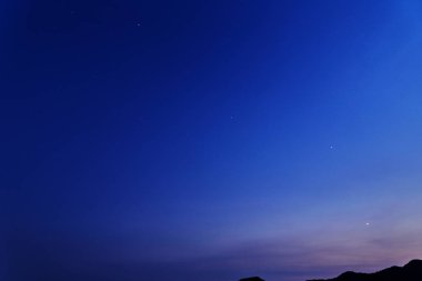 gece gökyüzünde yıldızlar tarafından dağ sonra günbatımı ile