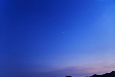 gece gökyüzünde yıldızlar tarafından dağ sonra günbatımı ile