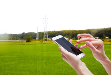 Beyaz arka plan üzerinde izole cep telefonuna yazarak bir kadın portre çekim... Figer ile dönük ve modern bir akıllı telefon tutarak kızın elini. Kendi Web sayfası veya mesaj koymak için boş ekran.