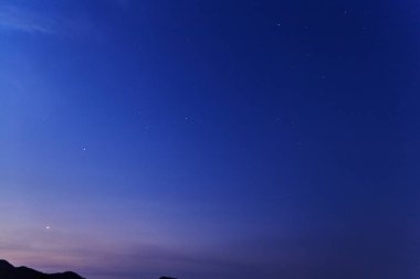 gece gökyüzünde yıldızlar tarafından dağ sonra günbatımı ile