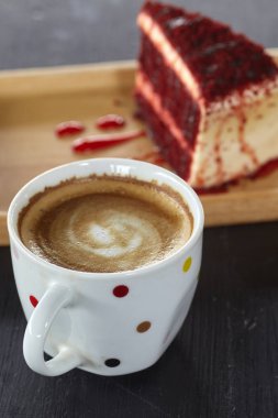 Kahve fincanı ve Red Velvet Cake sabah güneşi ile masada. Tatil tasarım için mektup için boşluk