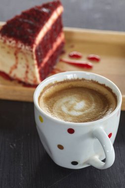 Kahve fincanı ve Red Velvet Cake sabah güneşi ile masada. Tatil tasarım için mektup için boşluk