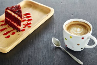 Kahve fincanı ve Red Velvet Cake sabah güneşi ile masada. Tatil tasarım için mektup için boşluk