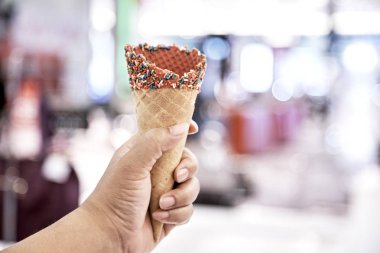 Dondurma kapalı alışveriş merkezi için boş gofret koni tutan el. Yakın, yüksek çözünürlüklü ürün
