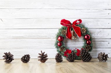 Çam kozalakları ve eski ahşap masa bir beyaz duvar ahşap arka plan, metin, düz yatıyordu için yer üzerinde kırmızı meyveler ile Noel çelenk görüntülemek yukarıdan