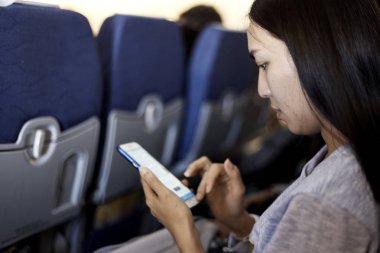 Genç kadın Asya Uçak, dünya seyahat kavramı, gece lambası smartphone kullanarak