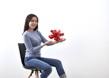 Güzel seksi genç Asyalı kadın hediye kutusu beyaz arka planda, resmi bir sandalyede oturan içeren alanı Kopyala