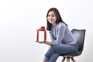 Güzel seksi genç Asyalı kadın hediye kutusu beyaz arka planda, resmi bir sandalyede oturan içeren alanı Kopyala
