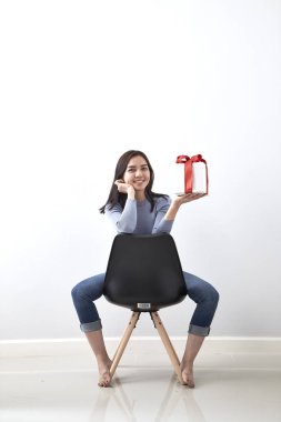 Güzel seksi genç Asyalı kadın hediye kutusu beyaz arka planda, resmi bir sandalyede oturan içeren alanı Kopyala