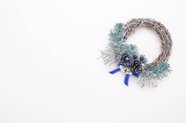 Beyaz duvar süslemeleri ile yeşil ve mavi Noel çelenk