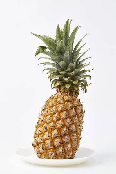 ripe pineapple in white plate isolated studio shoot on white background, Light emulates natural light with space for design.