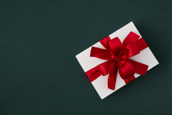 Beautiful Gift Box with Ribbon on green paper background
