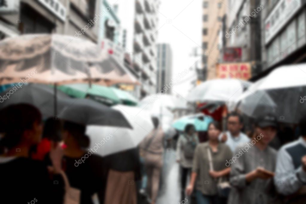 Blurred People holding umbrellas the street in the city, Tokyo in Japan