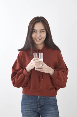 Güzel genç Asyalı kadın beyaz duvar arka planda içme sütü