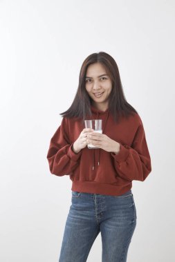 Güzel genç Asyalı kadın beyaz duvar arka planda içme sütü