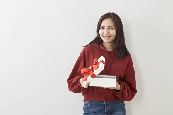 Junge Asiatische Frau Zeigen Mit Einem Geschenkkarton Auf Hellgrauem Wandhintergrund — Stockfoto