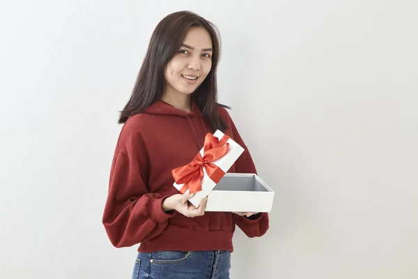 Junge Asiatische Frau Zeigen Mit Einem Geschenkkarton Auf Hellgrauem Wandhintergrund — Stockfoto