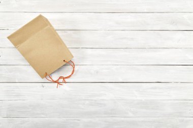 Alışveriş çantası kağıt kahverengi sürpriz hediye Beyaz ahşap arka plan kopya alanı ile boş alanı tasarım, biyolojik malzeme çevreye dost.