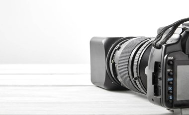 Eski dijital fotoğraf siyah Dslr fotoğraf makinesi tele lens Beyaz ahşap zemin üzerinde