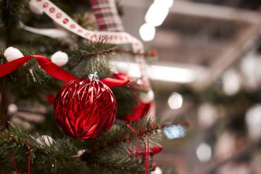 Dekore edilmiş bir Noel ağaca tutunan kırmızı önemsiz şey closeup.