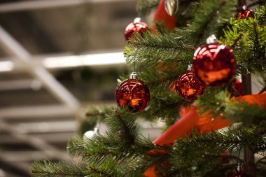 Dekore edilmiş bir Noel ağaca tutunan kırmızı önemsiz şey closeup.