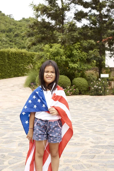 Cute Little asian girl and American flag Backyard in home