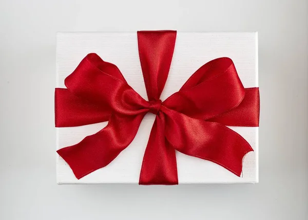 上面的礼物包裹着一个红色的丝带在白色背景 — 图库照片
