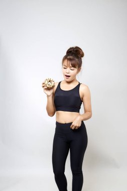 Çörekler abur cubur ile beyaz zemin üzerine, kavram sağlıklı gıdalar tutan genç kadın yoga