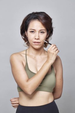 Gri arka plan, güzel moda kavramı üzerinde Kaş Fırçası aracıyla closeup güzel kadın