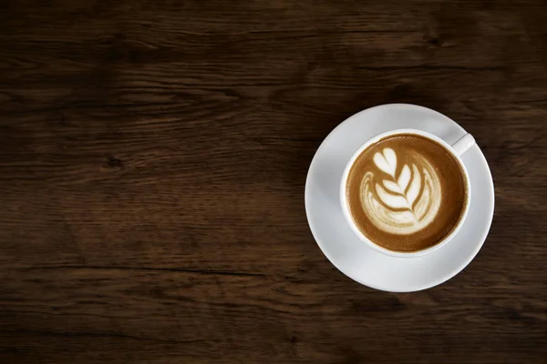 Hot coffee latte cup on wood table background with warm morning sunlight. happy weekend concept.