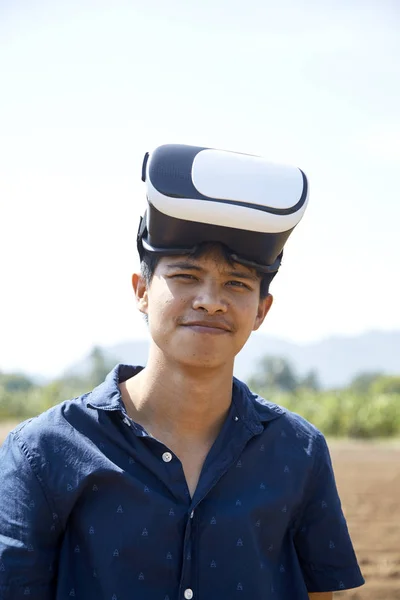 Азиатский Мужчина Наслаждается Виртуальной Реальностью Сидя Траве Открытом Парке Устройство — стоковое фото