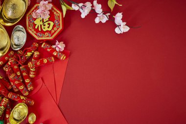 Çin yeni yılı 2019 festival decorations.firecrackers,gold külçe, kırmızı paket, Erik çiçeği, kırmızı zemin üzerine. Üstten görünüm aksesuarları. Çeviri: Fu iyi servet, bahar anlam Chun anlamı.