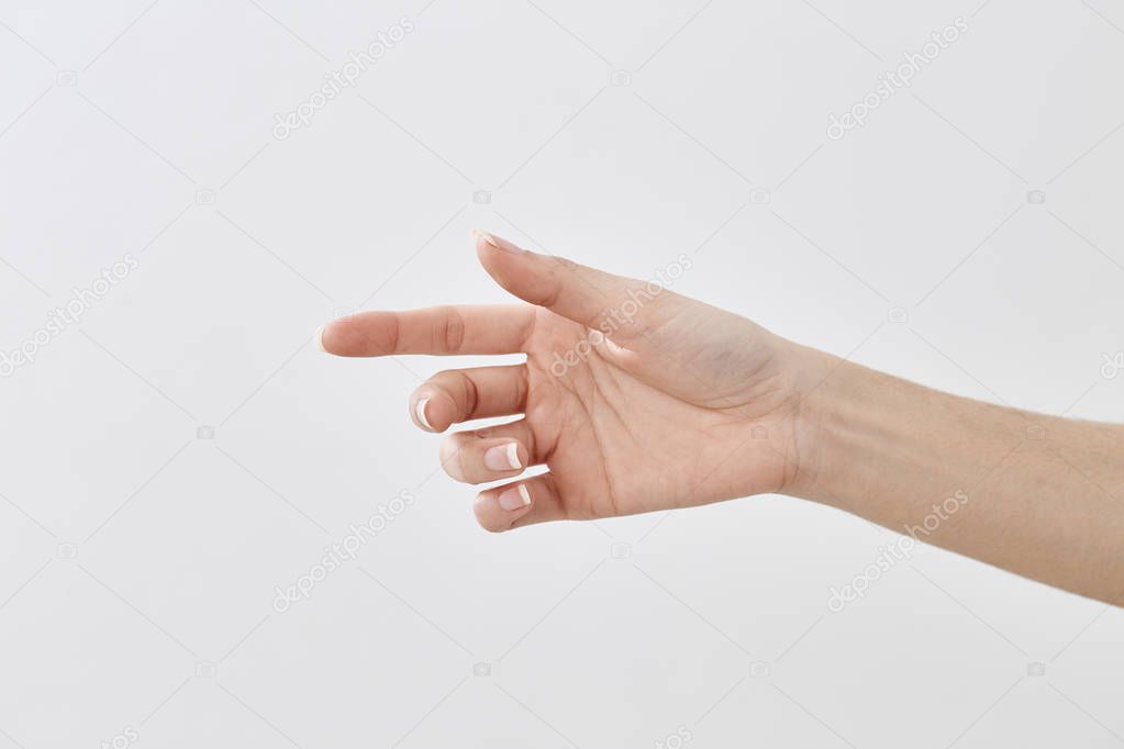 Closeup of female hand pointing isolated on white background. There is an empty space for the design of natural light.
