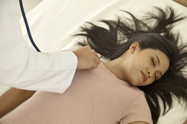 Hands of doctors giving cardiac massage and resuscitation to a female patient in the bedroom, Concept of Emergency Medical Team