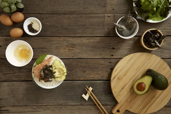 Avocado Hawaii food poke bowl Composition of kitchen devices on wooden table, Healthy Food Concepts, free copy space, flat lay food