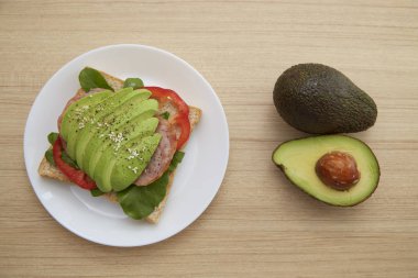 Sağlıklı sandviç avokado ve düzenlenen çavdar ekmeği ve ahşap zemin, sağlıklı gıda iş kavramlar üzerine karabiber serpin ile