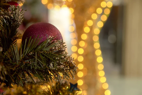 Christmas purple ball on tree with lights and stars