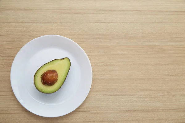 健康素食主义者 在棕色木桌上的白色盘子上的鳄梨 — 图库照片