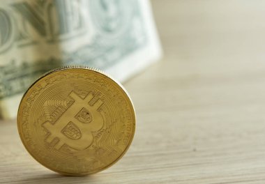 Bitcoin. Fiziksel bit sikke. Dijital para. Cryptocurrency. Ahşap masa arka plan yansıması, iş büyüme ile bitcoin sembolü ile altın sikke