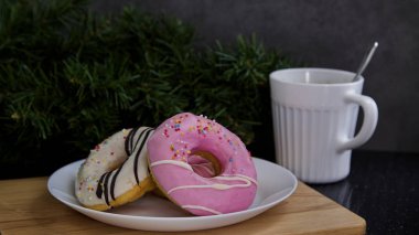 Pembe Donuts kahve ve koyu ahşap arka plan üzerinde plaka üzerinde karanlık gıda fotoğrafçılığı kavramı